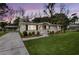 Single-story home featuring a manicured front yard, mature trees, and a charming walkway to the entrance at 1239 Old Orchard Rd, Charleston, SC 29412
