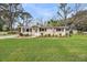 Charming single-story home boasts a well-manicured lawn, flowering bushes, and a paved walkway to the front door at 1239 Old Orchard Rd, Charleston, SC 29412