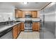 Well-lit kitchen featuring stainless steel appliances, wooden cabinets, and durable countertops at 1239 Old Orchard Rd, Charleston, SC 29412