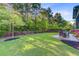 Grassy backyard featuring a patio with outdoor seating, garden beds, and a wooded backdrop at 132 Daniels Ridge Dr, Summerville, SC 29485