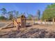 Well-equipped community playground featuring a play structure with slide, swing set, climbing wall, and a white picket fence at 132 Daniels Ridge Dr, Summerville, SC 29485
