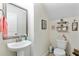 Cozy powder room with pedestal sink, framed mirror and decorative shelving around the toilet at 132 Daniels Ridge Dr, Summerville, SC 29485