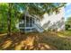 View of the back of a home with a screened-in porch and mature trees at 133 Hanahan Plantation Cir, Hanahan, SC 29410