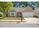 Charming single-story home with manicured lawn, attached garage, and mature trees at 1362 Palm Cove Dr, Charleston, SC 29492