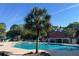 Resort-style pool with tropical landscaping, sun loungers, and community buildings in view at 1362 Palm Cove Dr, Charleston, SC 29492