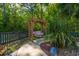 Charming backyard swing beneath a wooden pergola, surrounded by lush greenery and a peaceful setting at 1440 Teaberry Path, Charleston, SC 29414