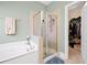 Bathroom featuring soaking tub and glass-enclosed shower at 1440 Teaberry Path, Charleston, SC 29414