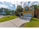 Charming yellow two-story home with a well-manicured lawn and a long driveway at 1440 Teaberry Path, Charleston, SC 29414