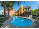 Backyard swimming pool featuring patio with dining, lush landscaping and rear of yellow home at 1440 Teaberry Path, Charleston, SC 29414