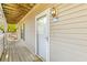 Exterior view of a balcony featuring a door and light fixture against beige vinyl siding at 1530 Fort Johnson Rd # 3C, Charleston, SC 29412