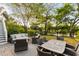 Backyard patio with wicker seating, a wooden dining table, and a view of a pond surrounded by mature trees at 158 Mary Ellen Dr, Charleston, SC 29403