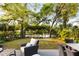 Lush backyard with lounge area, dining table, and mature trees surrounding the outdoor space at 158 Mary Ellen Dr, Charleston, SC 29403