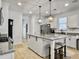 Well-lit kitchen features an island with granite countertops, white cabinets, and pendant lighting at 1673 Emmets Rd, Johns Island, SC 29455