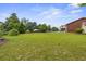 Expansive backyard view with a small shed, some trees, and a lawn leading back to the main house at 200 Broughton Rd, Moncks Corner, SC 29461