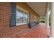 Covered porch showcasing brick flooring, classic columns, and comfortable seating at 200 Broughton Rd, Moncks Corner, SC 29461