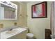 A cozy bathroom has a vanity, framed mirror with lights, a toilet, and a matching painting on the wall at 201 Judith Dr, Summerville, SC 29485