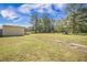 Large, grassy backyard with shed, shelter, and partial fencing; ideal for outdoor activities and storage at 208 Mini Farm Rd, Bonneau, SC 29431