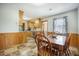 Inviting dining area with wood-paneled walls, view into kitchen with granite countertops at 208 Mini Farm Rd, Bonneau, SC 29431