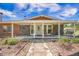 Front porch with rocking chairs, brick columns, and a walkway leading to the entrance at 208 Mini Farm Rd, Bonneau, SC 29431