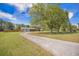 Attractive home featuring a long gravel driveway, mature trees, and a spacious front yard at 208 Mini Farm Rd, Bonneau, SC 29431