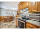 Open kitchen area with dining table, stainless steel appliances, and wooden cabinets at 208 Mini Farm Rd, Bonneau, SC 29431