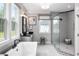 Bright bathroom features a large walk-in shower, a soaking tub, and dual windows bringing in natural light at 208 Quimby Hill Dr, Huger, SC 29450