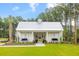 Charming clubhouse exterior with a metal roof and inviting porch swings, set amidst a manicured lawn at 208 Quimby Hill Dr, Huger, SC 29450