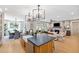 A modern kitchen with sleek cabinets, an island with seating, and open to the living and dining areas at 208 Quimby Hill Dr, Huger, SC 29450