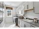 Well-lit laundry room with sleek cabinetry, modern appliances, and a practical sink for added convenience at 208 Quimby Hill Dr, Huger, SC 29450