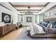 Comfortable main bedroom features a chandelier, wood beam ceiling, and large windows with plenty of natural light at 208 Quimby Hill Dr, Huger, SC 29450