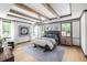 Inviting main bedroom features a decorative chandelier, wood beam ceiling, and two large windows at 208 Quimby Hill Dr, Huger, SC 29450