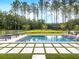 A stunning backyard pool surrounded by lush green grass and stone tiles is perfect for relaxation at 208 Quimby Hill Dr, Huger, SC 29450