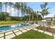 A luxurious backyard oasis featuring a pool, built-in grill, outdoor seating and lush landscaping at 208 Quimby Hill Dr, Huger, SC 29450