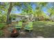Lush backyard with a fire pit and colorful Adirondack chairs, creating a cozy outdoor space at 23 Hunters Forest Dr, Charleston, SC 29414