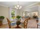 Elegant dining area with a glass table set for four, seamlessly flowing into the living room and kitchen at 23 Hunters Forest Dr, Charleston, SC 29414