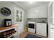Well-lit laundry room featuring modern washer and dryer, storage cabinets, and a door to the outside at 23 Hunters Forest Dr, Charleston, SC 29414