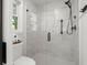 Close-up of glass-enclosed shower featuring white tile, black hardware, and shower seat at 23 Hunters Forest Dr, Charleston, SC 29414
