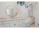 Bright bathroom featuring double vanities with white cabinets, stone countertops, and round mirrors at 2455 The Bent Twig, Seabrook Island, SC 29455