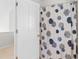 Bathroom with an open white door showing access to a shower with patterned curtain and silver rod at 2455 The Bent Twig, Seabrook Island, SC 29455