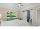 Bright bedroom with neutral walls, white bedding, ceiling fan, and view of nature at 2455 The Bent Twig, Seabrook Island, SC 29455