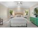 Bright bedroom with neutral walls, white bedding, ceiling fan, and view of nature at 2455 The Bent Twig, Seabrook Island, SC 29455