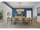 Open dining room with a long table, seating for eight, modern light fixture, and blue accent wall at 2455 The Bent Twig, Seabrook Island, SC 29455