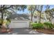 Home featuring attached garage, neat landscaping, and a charming bench by the driveway at 2455 The Bent Twig, Seabrook Island, SC 29455