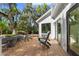 Outdoor deck with seating area and glass door, offering scenic views of the yard with mature trees at 2455 The Bent Twig, Seabrook Island, SC 29455