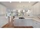 Modern open-concept kitchen boasts hardwood floors, stainless steel appliances, and white cabinets at 3007 Cameron Blvd, Isle of Palms, SC 29451