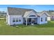 A backyard with a screened porch, perfect for enjoying the outdoors and the well-maintained green lawn at 308 Cypress Branch Rd, Huger, SC 29450