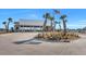 Clubhouse surrounded by manicured landscaping, palm trees, and an American flag at 308 Cypress Branch Rd, Huger, SC 29450