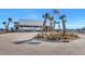 Clubhouse surrounded by manicured landscaping, palm trees, and an American flag at 308 Cypress Branch Rd, Huger, SC 29450