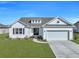 Charming single-story home features a manicured lawn, two-car garage, and classic white siding at 308 Cypress Branch Rd, Huger, SC 29450