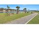 Horseshoe pit near a lake with palm trees, park benches, and a paved walkway in a community at 308 Cypress Branch Rd, Huger, SC 29450